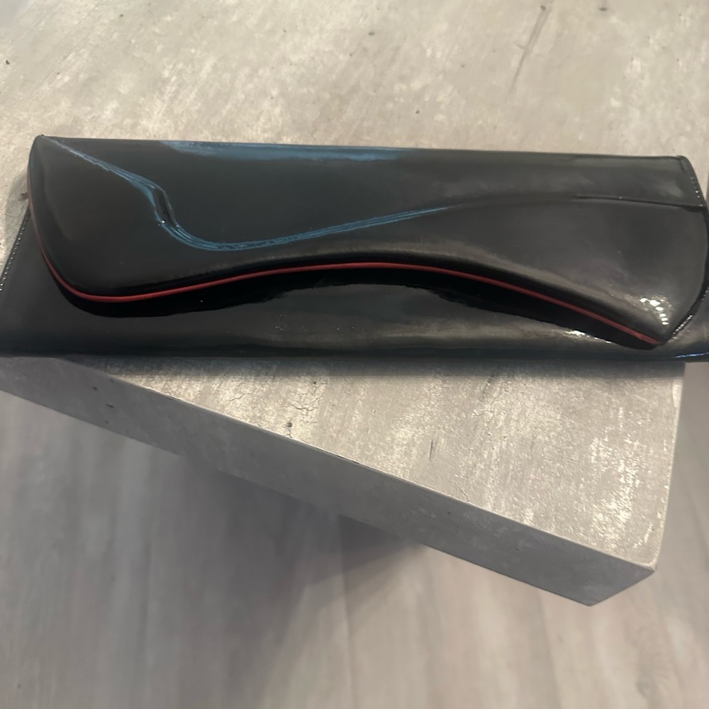 Christian Louboutin Black Cluth with Red trimming. 12x 4 inch.
